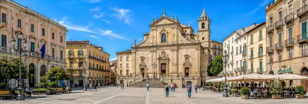 Sassari, Italy historic city square with ornate architecture, cathedral, and lively outdoor cafés