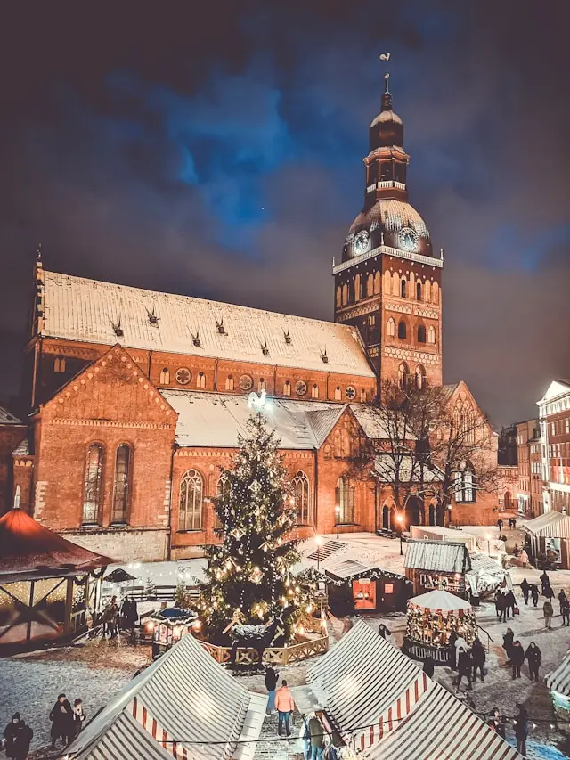 Riga Cathedral and Christmas market in Riga, Latvia, covered in snow at night