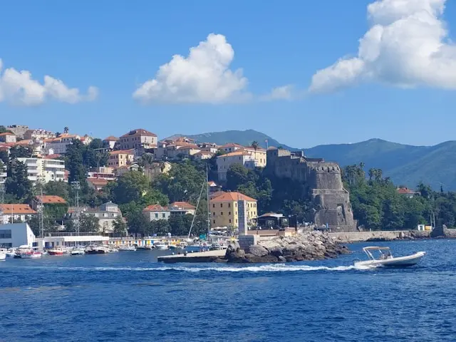 Coastal view of Herceg Novi with historic fortress walls and mountains in Montenegro