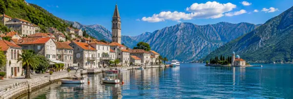 Historic Perast waterfront with St. Nicholas Church, Our Lady of the Rocks and Bay of Kotor mountains.