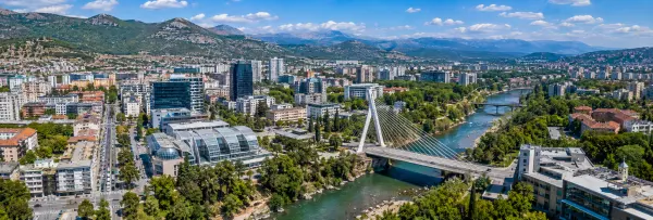 Aerial panoramic view of Podgorica, Montenegro, with the Morača River, Millennium Bridge and surrounding mountains