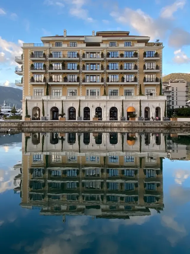 Waterfront hotel and marina reflected in the calm waters of Porto Montenegro