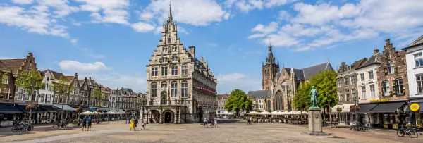 Gouda historic market square with the ornate old town hall and Gothic Sint-Janskerk in the Netherlands