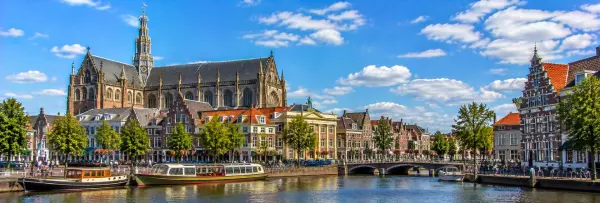 Haarlem Netherlands with Grote Kerk, historic canal, boats and traditional Dutch buildings