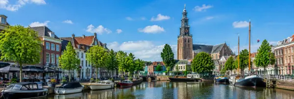 Leeuwarden, Netherlands historic canal with boats, traditional buildings, and the Oldehove tower