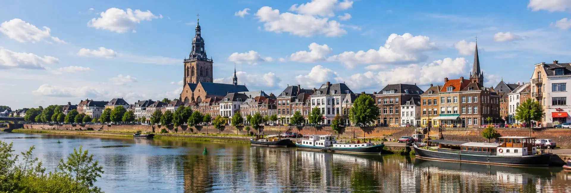 Roermond waterfront with historic buildings, boats and Munsterkerk in the Netherlands
