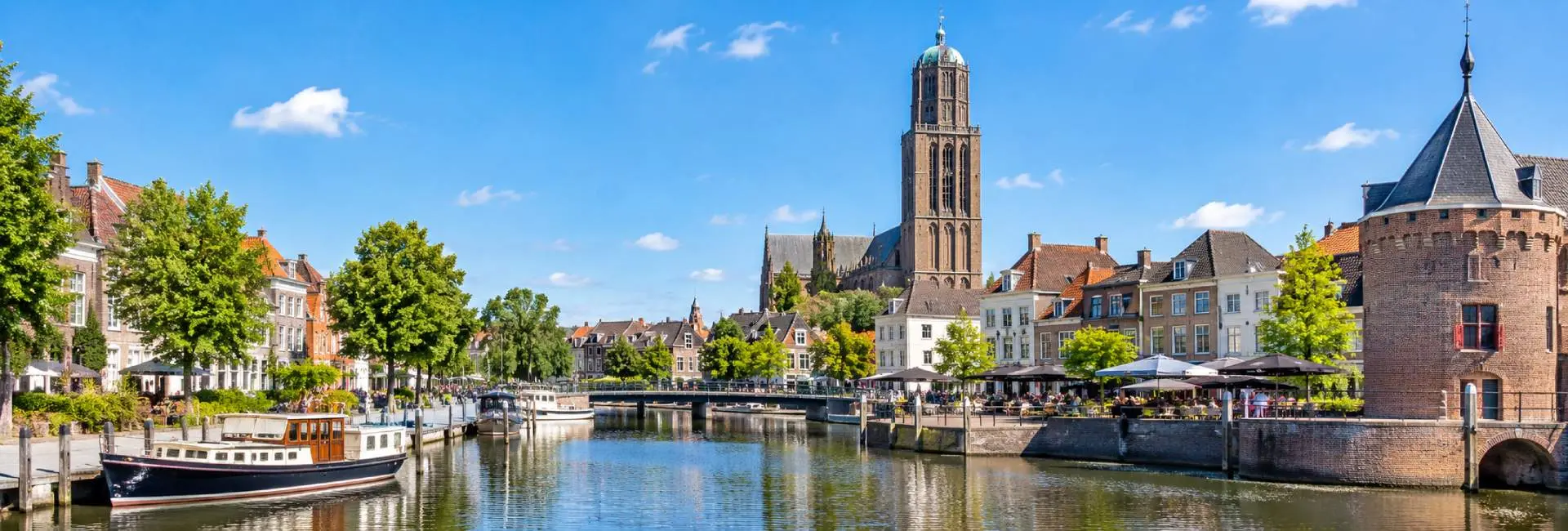 Zwolle, Netherlands, with its historic waterfront, boats, and distinctive church tower.