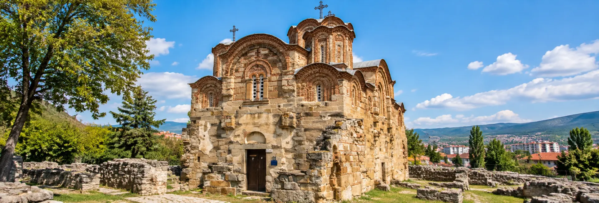 Historic Byzantine church in Kumanovo, North Macedonia, with intricate stonework, arches and surrounding ruins