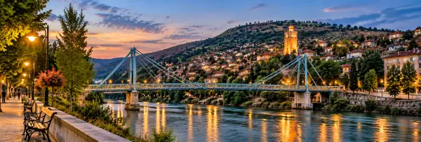 Veles, North Macedonia, with the Vardar River, steel bridge, hillside homes and illuminated Clock Tower