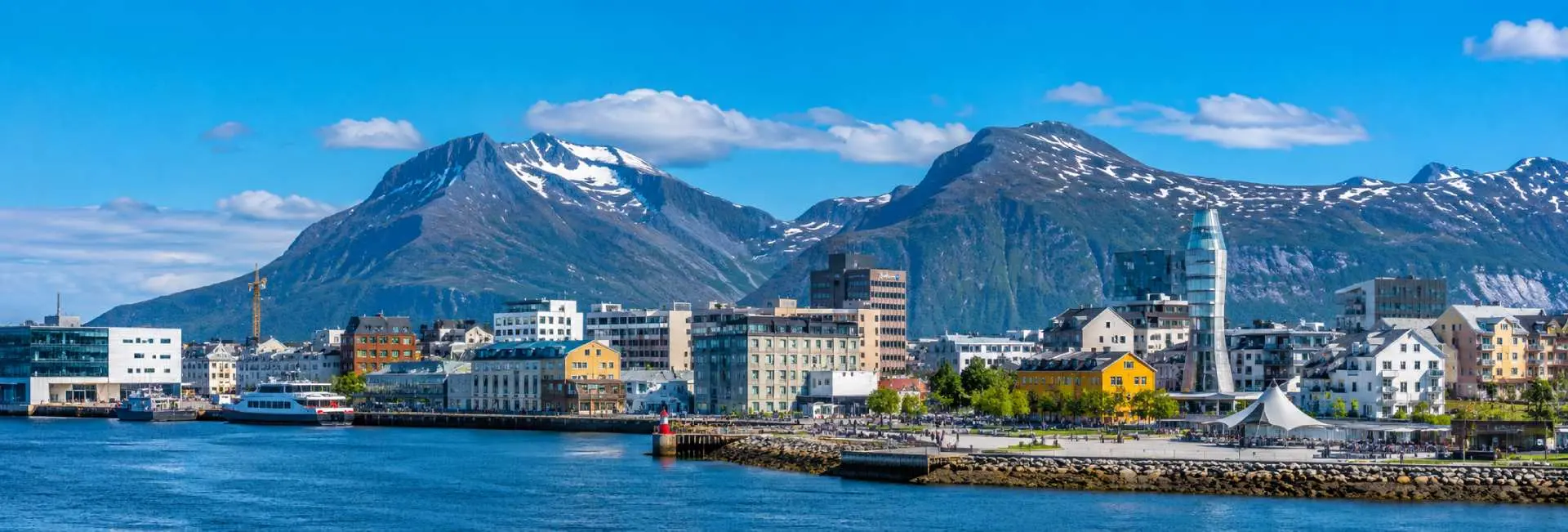 Bodø, Norway waterfront with colorful buildings, harbor and dramatic snow-capped mountains