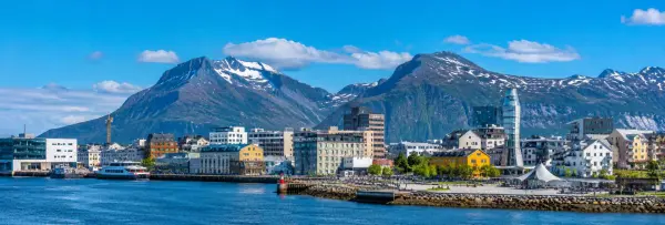 Bodø, Norway waterfront with colorful buildings, harbor and dramatic snow-capped mountains