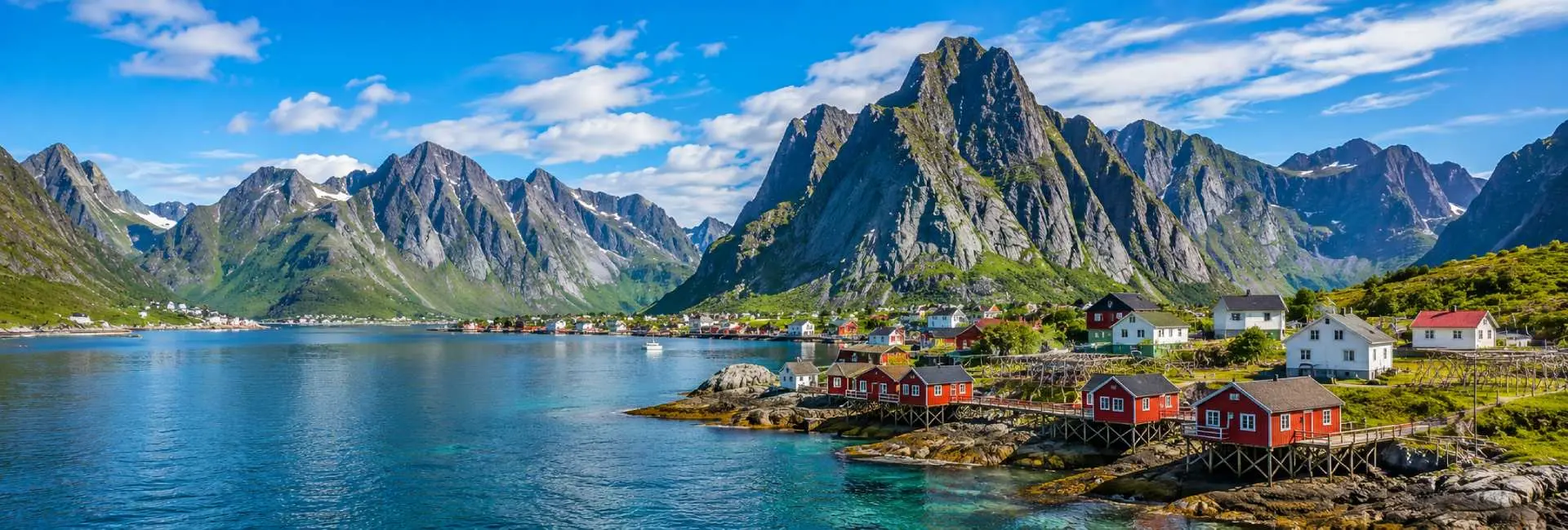 Lofoten Islands landscape with rugged mountains, fjord and traditional red fishing cabins