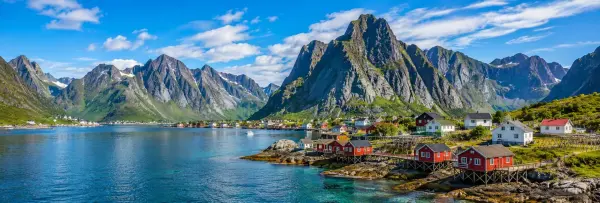 Lofoten Islands landscape with rugged mountains, fjord and traditional red fishing cabins