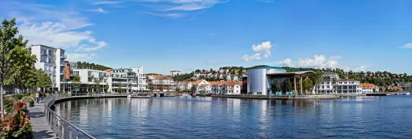 Sandnes, Norway waterfront with modern buildings, marina, hills and clear blue sky