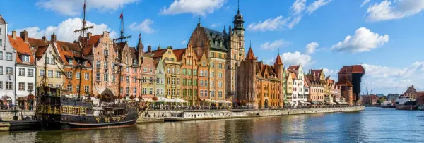 Historic Motława waterfront with colorful buildings and the medieval Crane in Gdańsk, Poland.