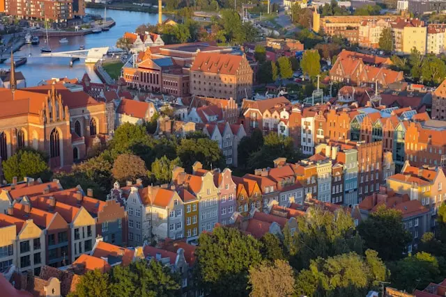 Aerial view of Gdańsk, Poland, showing historic red-roofed buildings, churches, and waterways