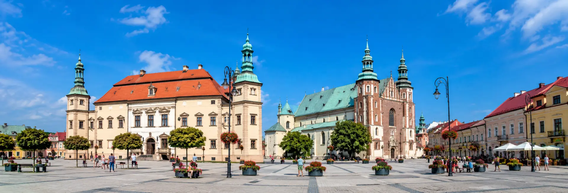 Historic city square and architecture in Kielce, Poland under a bright blue sky