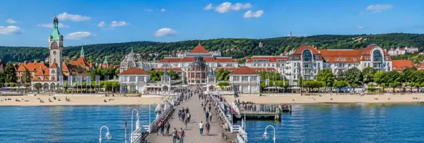 Sopot Pier extending into the Baltic Sea with the historic seaside resort and beach in Sopot, Poland.