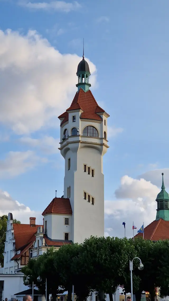 Historic white tower with red tiled roofs against a blue sky