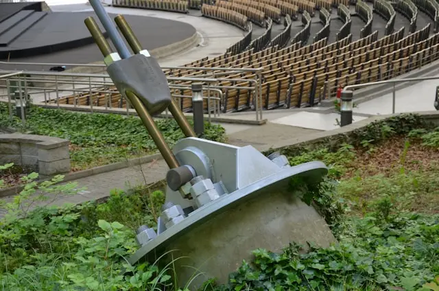 Outdoor amphitheater seating viewed from behind a large metal stage mechanism