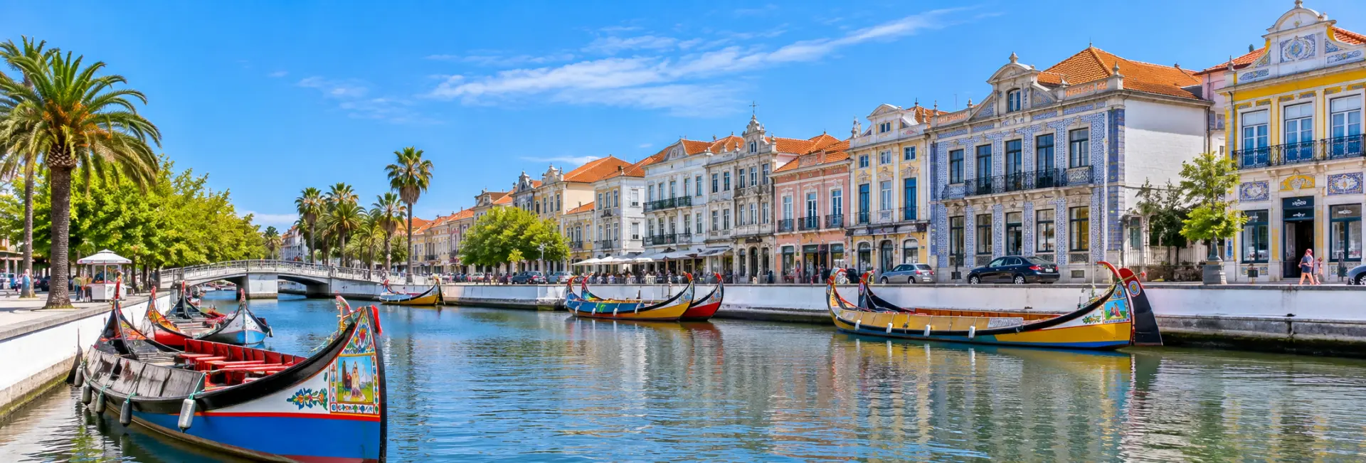 Aveiro, Portugal, with colorful moliceiro boats, canals, palm trees, and historic Art Nouveau buildings.