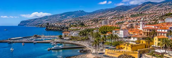 Funchal, Portugal, with its Atlantic waterfront, hillside buildings, marina and green mountains