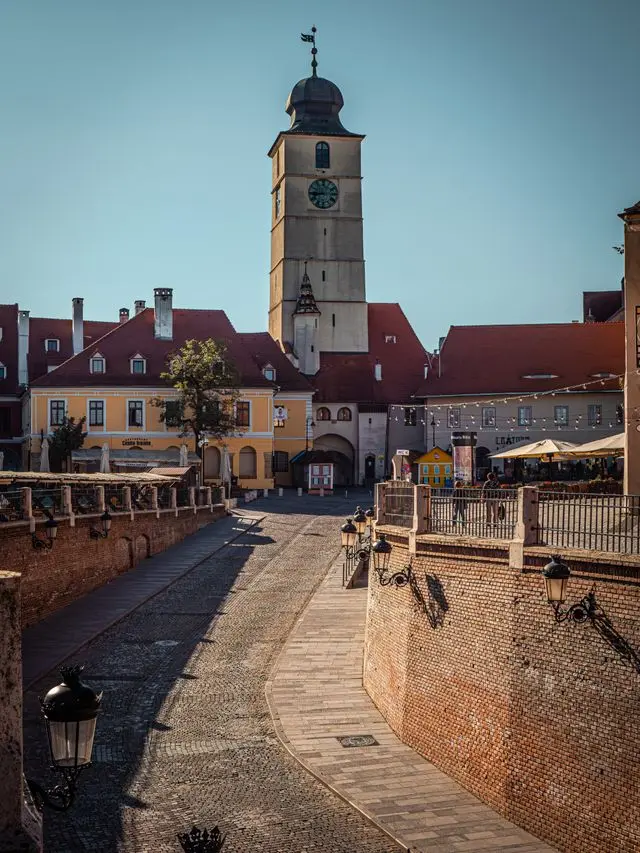 Historic clock tower and cobblestone square in Sibiu, Romania
