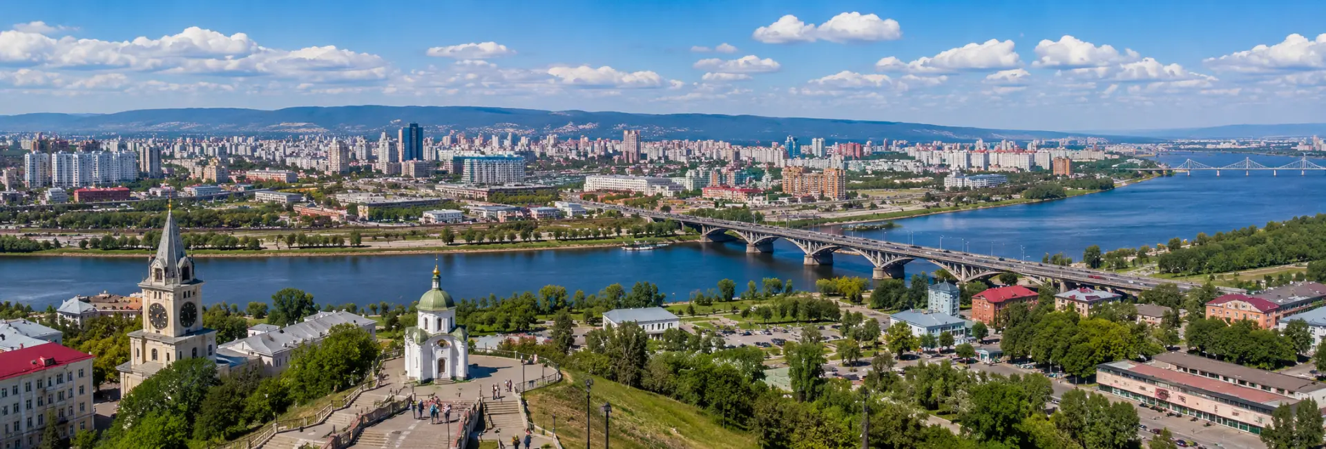 Krasnoyarsk skyline along the Yenisei River with bridges and surrounding hills
