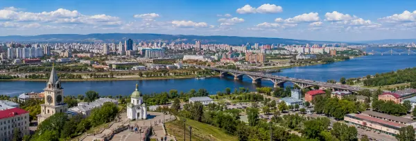 Krasnoyarsk skyline along the Yenisei River with bridges and surrounding hills