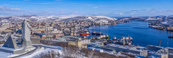 Murmansk skyline and harbor with the Alyosha monument and snow-covered Arctic hills
