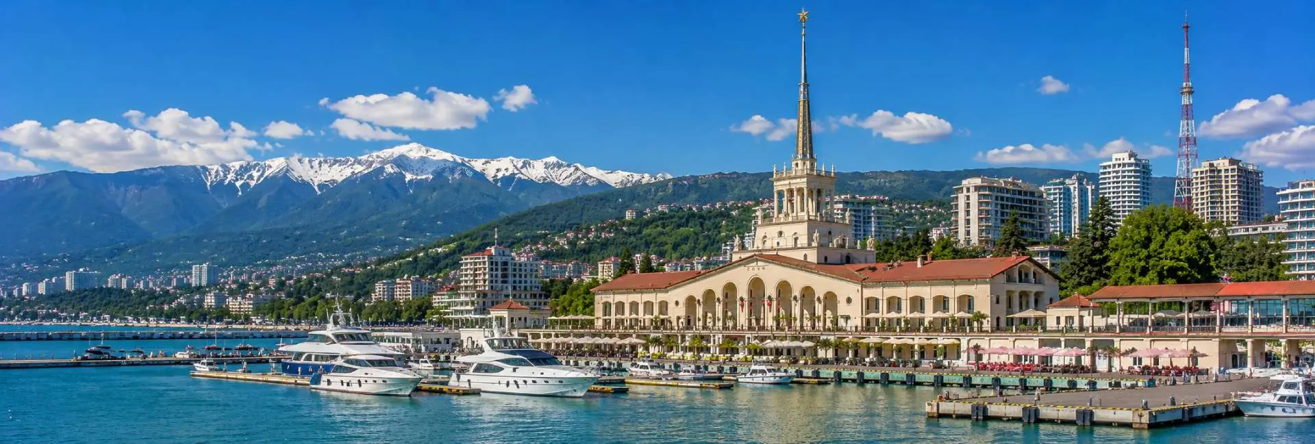 Sochi, Russia with the Black Sea marina, waterfront, mountains and historic railway station
