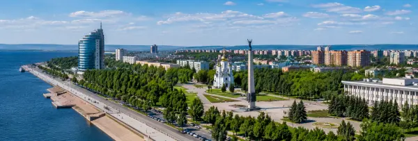 Aerial panoramic view of Tolyatti, Russia, with the Volga River, waterfront, city skyline, and landmarks.