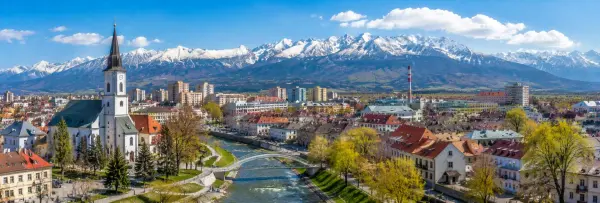 Poprad, Slovakia, with its historic church, city rooftops, river and snow-capped High Tatras mountains.