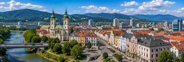 Žilina, Slovakia, with its historic center, twin-spired church, river and surrounding green mountains.