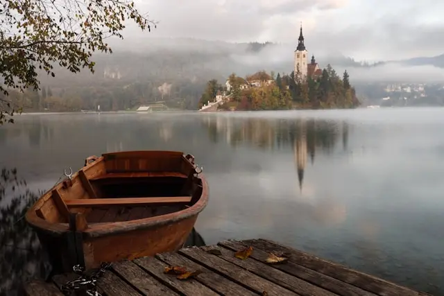 Traditional wooden boat on Lake Bled with Bled Island church in Slovenia