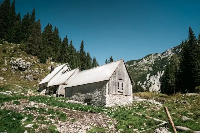 Traditional mountain hut surrounded by forests and limestone peaks near Bovec, Slovenia