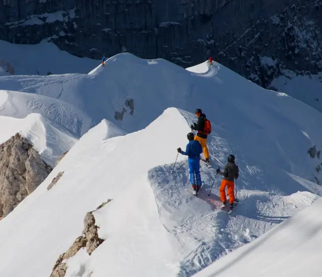 Skiers on a snowy mountain ridge in the Julian Alps near Bovec, Slovenia