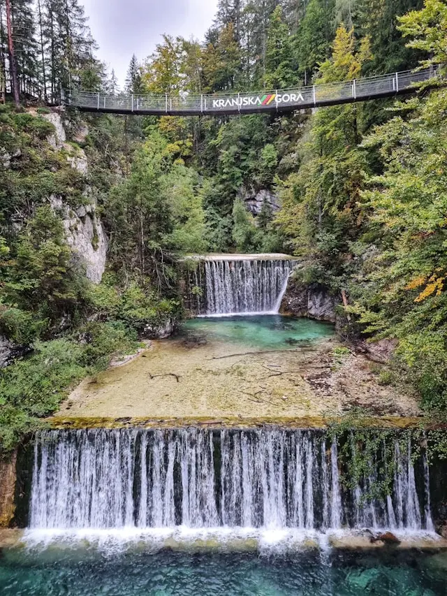 Waterfalls and Kranjska Gora footbridge in a forested gorge, Slovenia