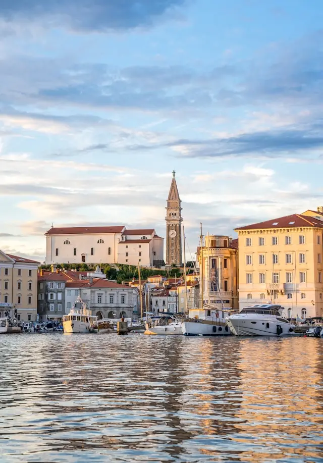 Piran waterfront with St. George’s Church bell tower and boats in Slovenia