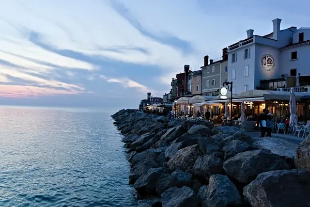 Piran seaside promenade with waterfront restaurants at sunset
