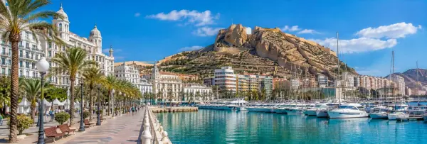 Alicante Spain waterfront with palm-lined promenade, marina, and Santa Bárbara Castle
