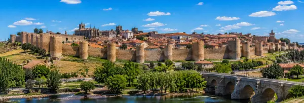 Ávila, Spain, featuring its medieval stone walls, historic old town, and cathedral under a clear blue sky