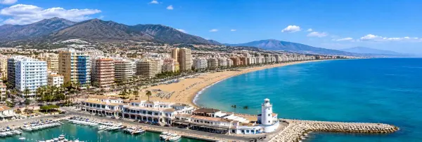 Aerial panoramic view of Fuengirola, Spain, with its beach, marina, Mediterranean coast and mountain backdrop