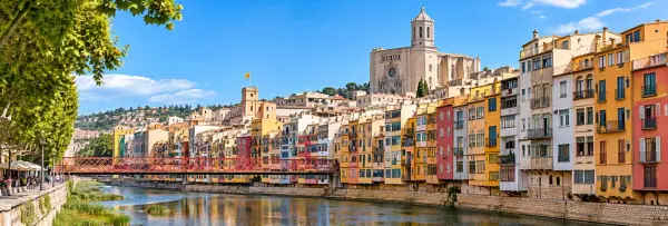 Colorful houses along the Onyar River with Girona Cathedral in Girona, Spain