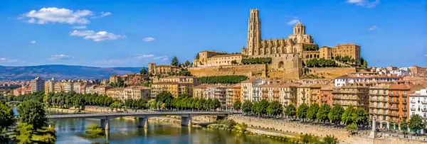 Panoramic view of Lleida, Spain, with the Segre River, Seu Vella cathedral, historic cityscape and surrounding hills