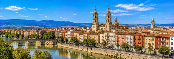 Panoramic view of Logroño, Spain, with the Ebro River, historic bridge, cityscape and mountain backdrop