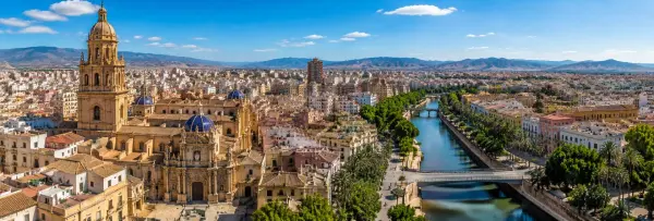 Aerial panoramic view of Murcia, Spain, featuring Murcia Cathedral, the Segura River and surrounding mountains