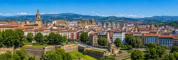 Pamplona, Spain skyline with historic fortress, churches, red rooftops and green mountains