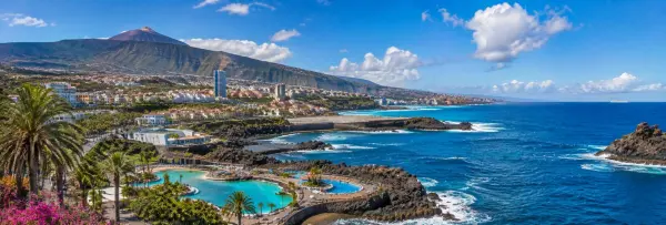 Tenerife, Canary Islands panoramic view of Mount Teide, volcanic coast, palm trees and Atlantic Ocean