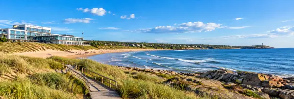 Tylösand Beach in Halmstad, Sweden, with sandy dunes, blue sea, coastal rocks, and the Tylösand resort